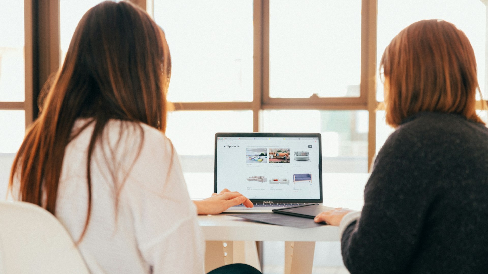 Contentspecialist bespreekt websitestructuur en contentstrategie achter een laptop tijdens een werksessie met een collega
